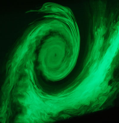 Photograph, taken in a wind tunnel, of the wake vortex of an aircraft at the end of the airfoil. Doppler Global Velocimetry is used to measure the velocity of flow at each point of a plane, illuminated by laser.
